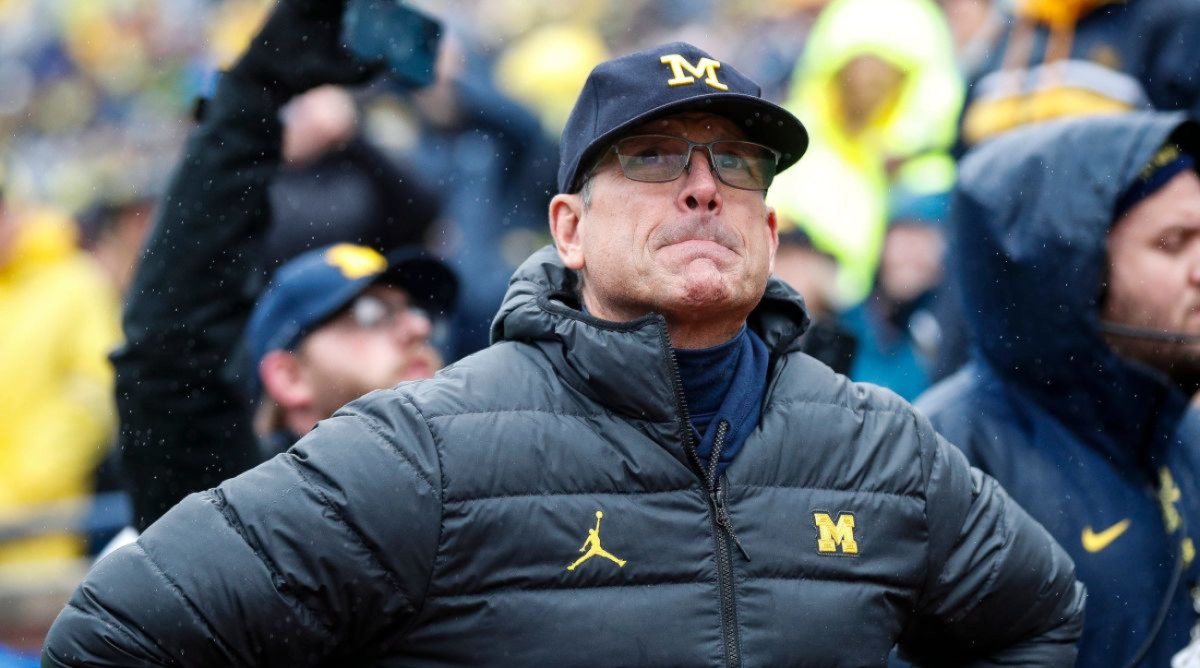 Michigan coach Jim Harbaugh poses on the sideline.